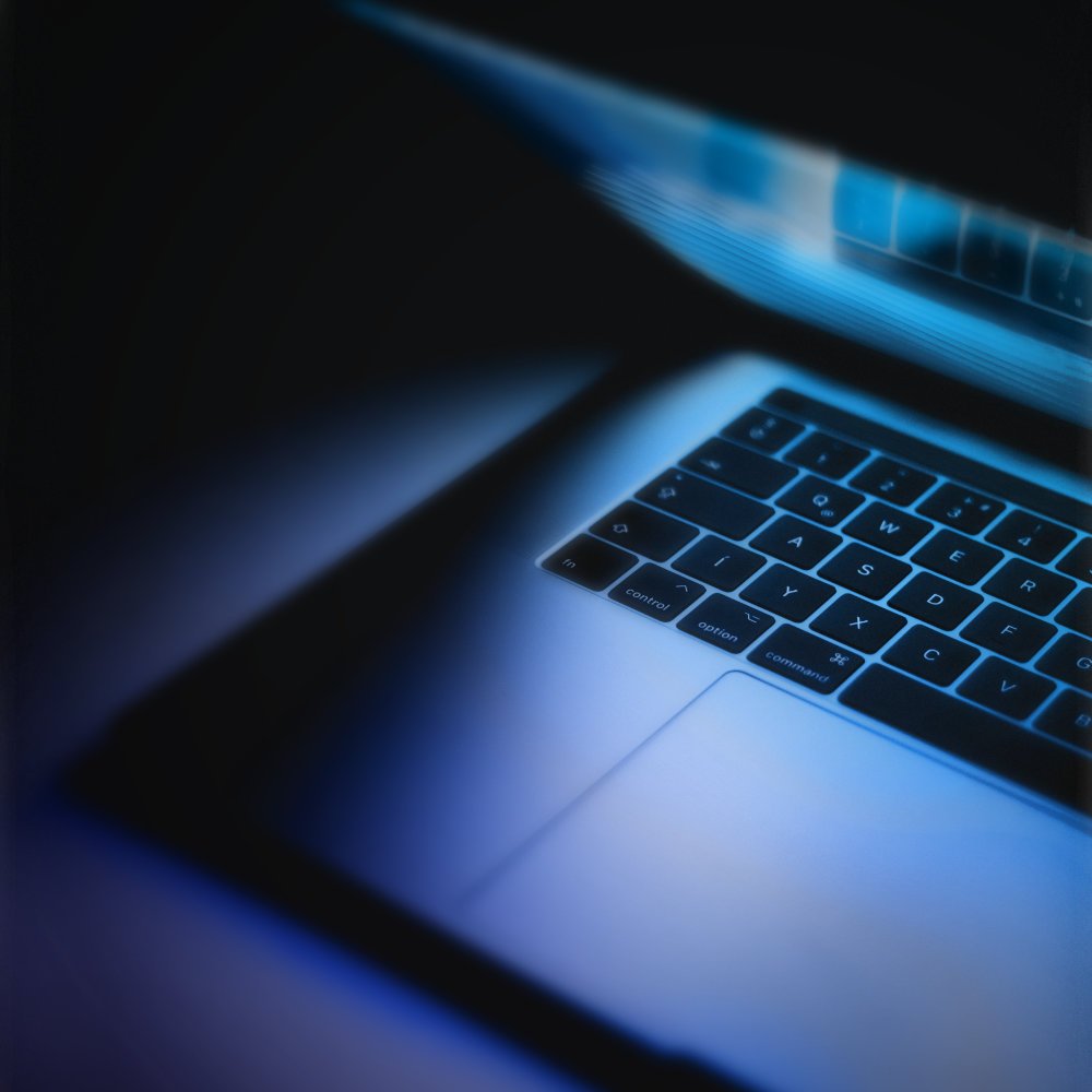 Geöffneter Laptop leuchtet in dunkler Umgebung